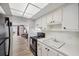 Kitchen with laminate floors, white cabinets, black appliances, and an open layout at 4775 Cove Cir # 205, St Petersburg, FL 33708