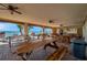 A waterfront outdoor seating area with picnic tables, ceiling fans, and waterfront views at 4775 Cove Cir # 205, St Petersburg, FL 33708