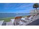 Relaxing patio lounge chairs overlooking the intercoastal waterway with boats and blue skies at 4775 Cove Cir # 205, St Petersburg, FL 33708
