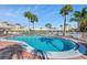 The property features a large swimming pool surrounded by a red brick patio and lounge chairs at 4775 Cove Cir # 205, St Petersburg, FL 33708
