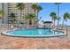 A luxurious swimming pool next to the building, surrounded by a brick patio with lounge chairs at 4775 Cove Cir # 205, St Petersburg, FL 33708