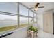 Sunroom showcasing large windows with water views, ceiling fan, and a storage cabinet at 4775 Cove Cir # 205, St Petersburg, FL 33708