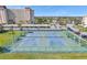 Community tennis courts surrounded by lush greenery, parking, and residential buildings at 4775 Cove Cir # 205, St Petersburg, FL 33708