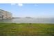 Expansive waterfront view with grassy lawn and serene bay, enhancing the tranquil residential setting at 4775 Cove Cir # 205, St Petersburg, FL 33708
