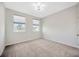 Bedroom featuring two sunny windows, carpeted floors, and neutral decor at 5080 Avalon Park Blvd, Wesley Chapel, FL 33545