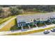 An aerial view showcases the exteriors of townhomes with sidewalks and greenery at 5080 Avalon Park Blvd, Wesley Chapel, FL 33545