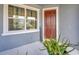 Inviting front porch featuring plants, a decorative sign, a welcome mat, and a freshly painted door at 5080 Avalon Park Blvd, Wesley Chapel, FL 33545