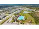 Aerial view of a community pool and playground surrounded by residential homes, ponds, and trees at 5080 Avalon Park Blvd, Wesley Chapel, FL 33545