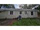 Image displays exterior features of this home and an air conditioning unit in the unkempt backyard at 53 Dolphin Dr # A, St Petersburg, FL 33706