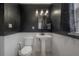 Stylish bathroom featuring textured dark walls, a pedestal sink, modern lighting, and classic tiling at 5502 N 9Th St, Tampa, FL 33604