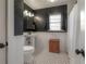 Elegant bathroom featuring a pedestal sink, textured walls, tiled floors, and a shower with white curtain at 5502 N 9Th St, Tampa, FL 33604