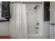 A white shower curtain hangs next to a shower with white subway tile in this bathroom at 5502 N 9Th St, Tampa, FL 33604