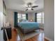 A cozy bedroom with a ceiling fan, warm wood floors, and a geometric rug at 5502 N 9Th St, Tampa, FL 33604