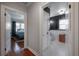 Hallway view featuring hardwood floors and entryways to a tiled bathroom and well lit bedroom at 5502 N 9Th St, Tampa, FL 33604