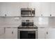 Modern kitchen with stainless steel appliances, white cabinets, subway tile backsplash, and quartz countertops at 5502 N 9Th St, Tampa, FL 33604