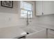Bright kitchen featuring a white farmhouse sink, quartz countertops, and a modern chrome faucet at 5502 N 9Th St, Tampa, FL 33604
