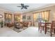 Bright living room featuring large windows with drapes, comfortable seating, and an adjacent dining space at 6214 45Th E Ln, Bradenton, FL 34203