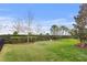 Spacious backyard featuring lush green grass, a black fence, and a small playhouse at 6219 Voyagers Pl, Apollo Beach, FL 33572