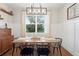 Charming dining room with a rustic wood table, black chairs, and a modern light fixture at 6219 Voyagers Pl, Apollo Beach, FL 33572