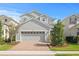 Charming two-story home featuring a brick driveway, a two-car garage, and well-maintained landscaping at 6219 Voyagers Pl, Apollo Beach, FL 33572