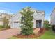 Beautiful two-story home with gray siding, brick driveway, blue door, and manicured front yard at 6219 Voyagers Pl, Apollo Beach, FL 33572