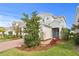 A charming gray two-story house with a brick driveway and a blue front door at 6219 Voyagers Pl, Apollo Beach, FL 33572