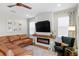 Comfortable living room with a cozy fireplace, leather sectional, and decorative accents at 6219 Voyagers Pl, Apollo Beach, FL 33572