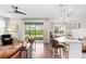 Open-concept living area with a leather sofa, kitchen island, and sliding glass doors to the backyard at 6219 Voyagers Pl, Apollo Beach, FL 33572