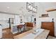 Open concept living space with kitchen island, dining table, and living room with a leather sofa at 6219 Voyagers Pl, Apollo Beach, FL 33572