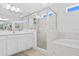 Bright main bathroom featuring a separate tub and shower with tile surround and white cabinetry at 6219 Voyagers Pl, Apollo Beach, FL 33572
