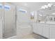 Bright main bathroom featuring a separate tub and shower with tile surround and white cabinetry at 6219 Voyagers Pl, Apollo Beach, FL 33572