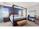 Beautiful main bedroom with a four poster bed, blue accent wall, and lots of natural light at 6219 Voyagers Pl, Apollo Beach, FL 33572