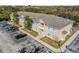 Aerial view of condo building, showcasing the parking lot, landscaping and nearby wooded area at 6414 Hollydale Pl # 101, Riverview, FL 33578