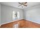 Bright bedroom with a ceiling fan and hardwood floors, complemented by natural light streaming through the window at 6414 Hollydale Pl # 101, Riverview, FL 33578