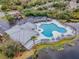 Aerial view of the community pool featuring ample seating and a lakeside view with mature landscaping at 6414 Hollydale Pl # 101, Riverview, FL 33578