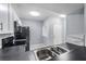 Efficient kitchen with stainless steel sink, black appliances, and black countertops at 6414 Hollydale Pl # 101, Riverview, FL 33578