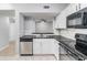 Kitchen featuring white cabinetry, black appliances, and a view to another room at 6414 Hollydale Pl # 101, Riverview, FL 33578