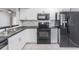 Modern kitchen with white cabinets, black countertops and stainless steel sink at 6414 Hollydale Pl # 101, Riverview, FL 33578