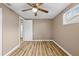 Neutral bedroom features a ceiling fan, wood floors, and a large window at 7507 Betula Dr, New Port Richey, FL 34653