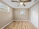 Neutral bedroom features a ceiling fan, wood floors, and double closet at 7507 Betula Dr, New Port Richey, FL 34653
