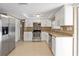 Modern kitchen featuring stainless steel appliances, granite countertops, and white cabinetry at 7507 Betula Dr, New Port Richey, FL 34653