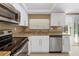 Bright kitchen featuring white cabinets, stainless steel appliances, and granite countertops at 7507 Betula Dr, New Port Richey, FL 34653