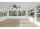 Bright sunroom with tile floors, a ceiling fan, and multiple windows at 7507 Betula Dr, New Port Richey, FL 34653