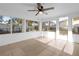 Bright sunroom with tile floors, a ceiling fan, and backyard access at 7507 Betula Dr, New Port Richey, FL 34653