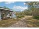 View of the screened pool, covered patio, and spacious backyard leading to a wooded area at 7546 Richland St, Wesley Chapel, FL 33544