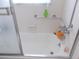Clean bathtub with a showerhead, tiled walls, a grab bar, and a partial glass enclosure for safety and convenience at 7729 39Th N Ter, St Petersburg, FL 33709