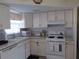 Well-lit kitchen featuring white cabinets, modern appliances, and ample counter space at 7729 39Th N Ter, St Petersburg, FL 33709