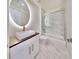 Modern bathroom featuring an illuminated mirror, frameless shower, and sleek vanity at 774 Gran Kaymen Way, Apollo Beach, FL 33572