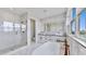 Elegant bathroom with a soaking tub, a glass-enclosed shower, and double sinks at 774 Gran Kaymen Way, Apollo Beach, FL 33572
