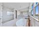 Elegant bathroom with a soaking tub, a glass-enclosed shower, and double sinks at 774 Gran Kaymen Way, Apollo Beach, FL 33572